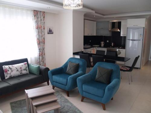 アブサルアにあるOrion Resort Zara 20のリビングルーム(ソファ、椅子付)、キッチンが備わります。