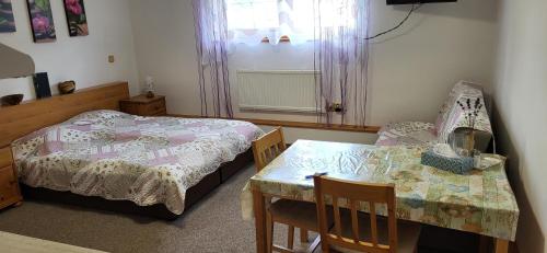 a bedroom with a bed and a table and chairs at Nika07 in Závažná Poruba