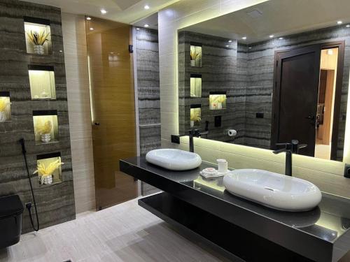 a bathroom with two sinks and a large mirror at Dar Zaha in Aguenouane