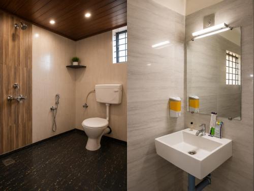 a bathroom with a toilet and a sink at Hotel Vijaya Suites in Manipal
