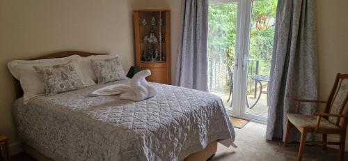 a bedroom with a bed with a white animal on it at Blackberry Cottage, Wood Farm in Shipdham