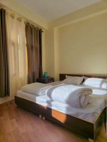 a bedroom with two beds with white sheets at Gyatso Home Saty in Kaza