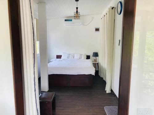 a bedroom with a bed in a white room at My Place Sri Lanka CMB Near Airport in Katunayaka