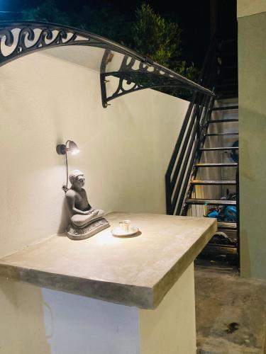 a statue of a person sitting on a table with a lamp at My Place Sri Lanka CMB Near Airport in Katunayaka