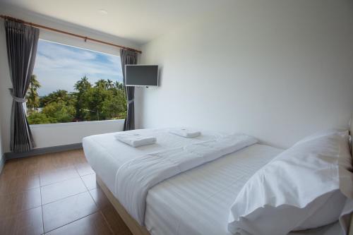 a bedroom with a white bed and a large window at P168 Hostel Samui in Chaweng