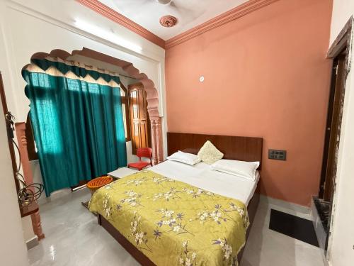 a bedroom with a bed and a green curtain at Hotel Ajanta in Pushkar