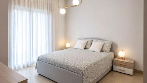 a white bedroom with a bed with two lamps on it at Casa Moscati in Avellino