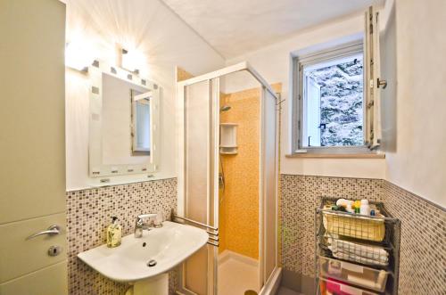 a bathroom with a sink and a shower with a window at Résidence Les Palmiers by Connexion in Cannes