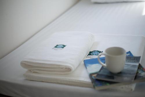 un mucchio di asciugamani e una tazza sul tavolo di P168 Hostel Samui a Chaweng Beach