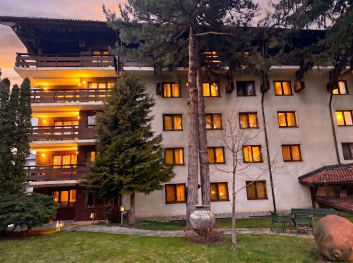 ein großes weißes Gebäude mit eingeschalteten Lichtern in der Unterkunft Hotel Pirin SKI & SPA in Bansko