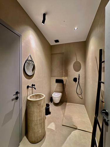 a bathroom with a tub and a toilet in it at Almond Chambers in Naousa