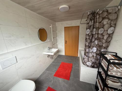 a bathroom with a sink and a toilet and a tub at Müllers Bergnest in Deggingen