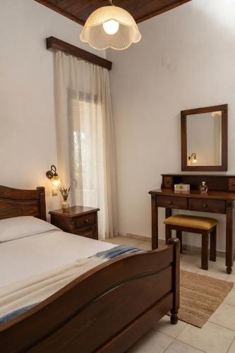 a bedroom with a bed and a desk and a mirror at Thodorou Sunset Villa in Stalos