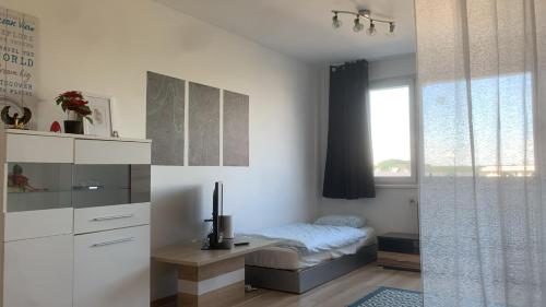 a bedroom with a bed and a desk and a window at 35 Square meter Apartment in Sankt Pölten