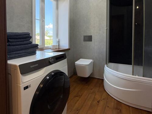a bathroom with a tub and a toilet and a sink at Дом с бассейном и мангальной зоной in Ustʼ-Kamenogorsk