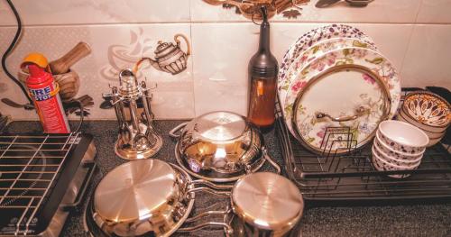 a counter top with dishes and a plate on a rack at 1 BHK by Agartha Atithya in Hyderabad