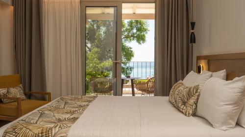 a bedroom with a large bed and a balcony at Eterrano Seaside Retreat in Parga