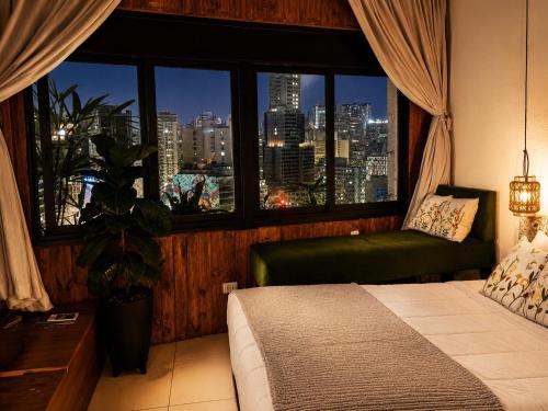 a bedroom with a bed and a window with a city view at Ryokan in São Paulo
