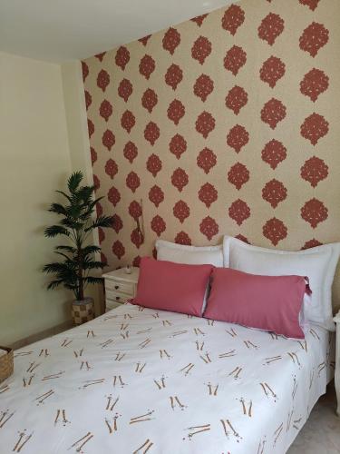 a bedroom with a white bed with pink pillows at Slow Life Bouznika in Bouznika