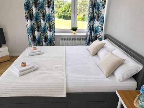 a bedroom with a bed with two towels on it at Radość z Marzeń in Suwałki
