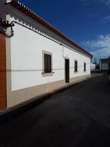 a white building with a window on the side of it at Refúgio do Artur - Casa no Campo in São Marcos do Campo