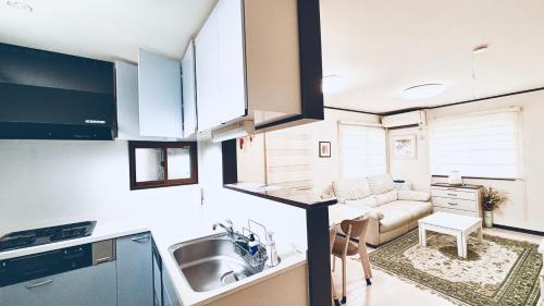 a kitchen and living room with a couch and a sink at Direct to every spots 4mins to station 4Lines for used Big House Family Direct Shinjuku Ikebukuro 3 Bedrooms Max for 8 people in Tokyo