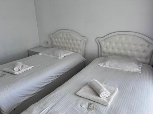 two beds with towels on them in a bedroom at Ala-Too Hotel in Naryn