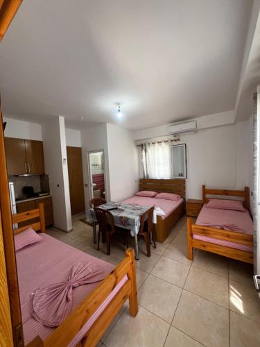 a room with two beds and a table in it at Eli Apartments in Tale