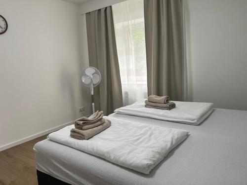 two beds with towels on them in a bedroom at Premium Apart Villa Hamburg in Hamburg