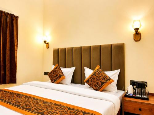 a bedroom with a large bed with orange and white pillows at Hotel CozyKey Rajpur Road in Dehradun
