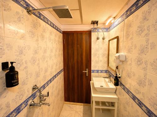 a bathroom with a sink and a mirror at Hotel CozyKey Rajpur Road in Dehradun
