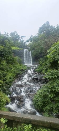 a river with a waterfall in a forest at Vihanka villa in Tāhārpur