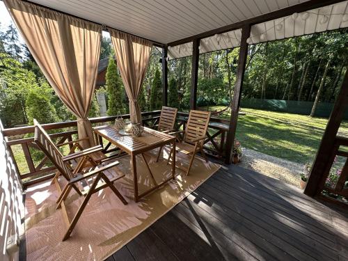 a patio with a table and chairs on a deck at Domek Pod Świerkami in Wólka