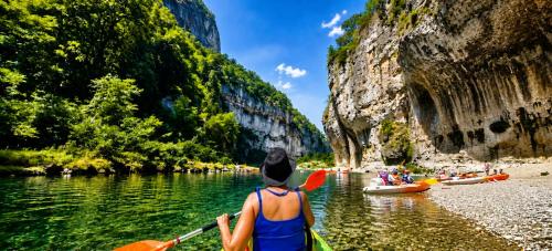 a woman in a kayak on a river in a canyon at LES GARGOUILLES - Piscine à Débordement Avec Vue Exceptionnelle - Gorges du Tarn - Millau in Boyne