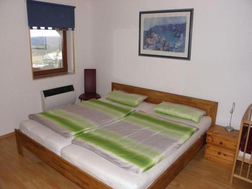 a bedroom with a large bed with green sheets at Ferienwohnung-Rurseeidyll in Simmerath