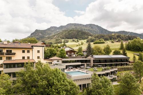 Blick auf ein Ferienresort mit Bergen im Hintergrund in der Unterkunft Hotel Alpenflora in Kastelruth