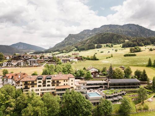 Eine Stadt in einem Tal mit Bergen im Hintergrund in der Unterkunft Hotel Alpenflora in Kastelruth