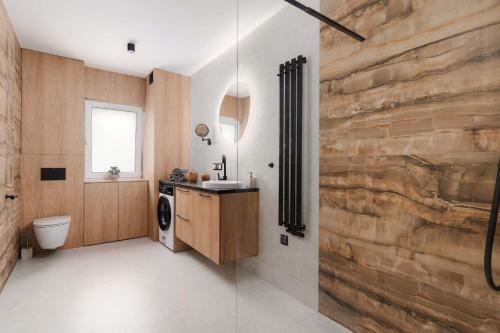 a bathroom with a stone wall and a washer and dryer at Ciche Tarasy in Stężyca