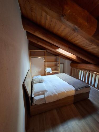 a large bed in a room with a wooden ceiling at Reinero Terrazza in Marmora