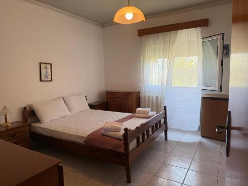 a bedroom with a bed and a window at Monastiraki Villa in Keramoti
