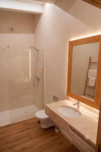 a bathroom with a sink and a toilet and a mirror at Herdade do Cascalhar in Vila do Bispo