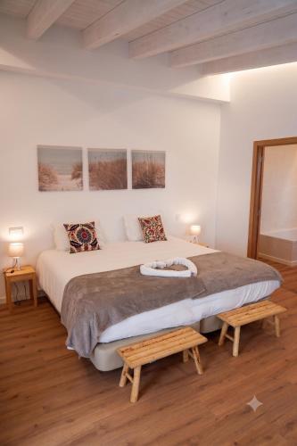 a bedroom with a large bed and two tables at Herdade do Cascalhar in Vila do Bispo