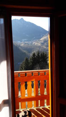 a dog laying on a balcony looking out a window at Chalet Il Fungo in Averara