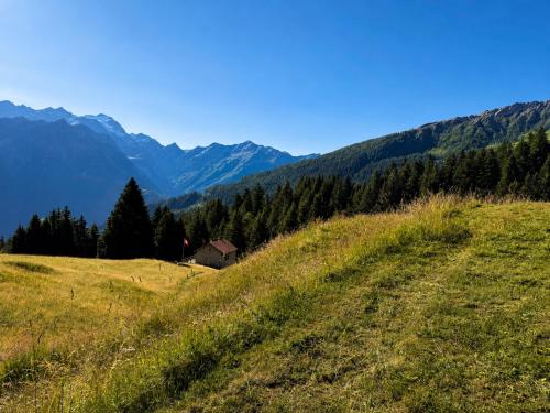 a grassy hill with a house in the distance at Casa Vista Adula, Unplug everything, breathe in Anvéuda