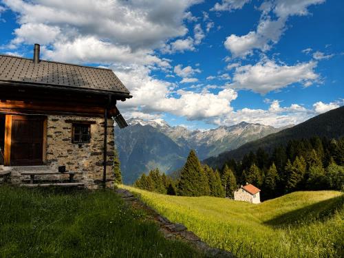 an old house on a hill with mountains in the background at Casa Vista Adula, Unplug everything, breathe in Anvéuda