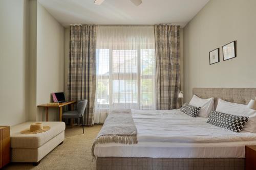 a bedroom with a large bed and a window at Palanga Visit Apartments and SPA in Palanga