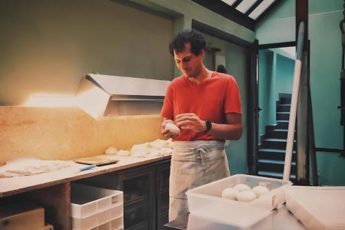 a man standing in a kitchen preparing food at Avenue Hostel & Suites in Lisbon