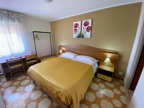 a bedroom with a yellow bed in a room at Albergo Mendolia in Milazzo