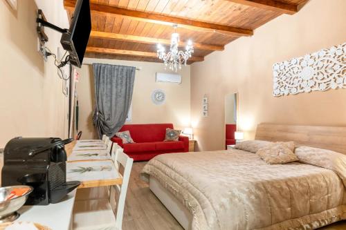 a bedroom with a bed and a red couch at B&B Le Carrube in Sava