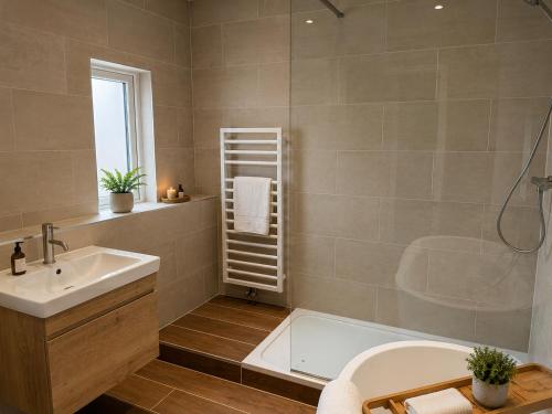 a bathroom with a tub and a sink and a shower at The Ainsty in Thorp Arch